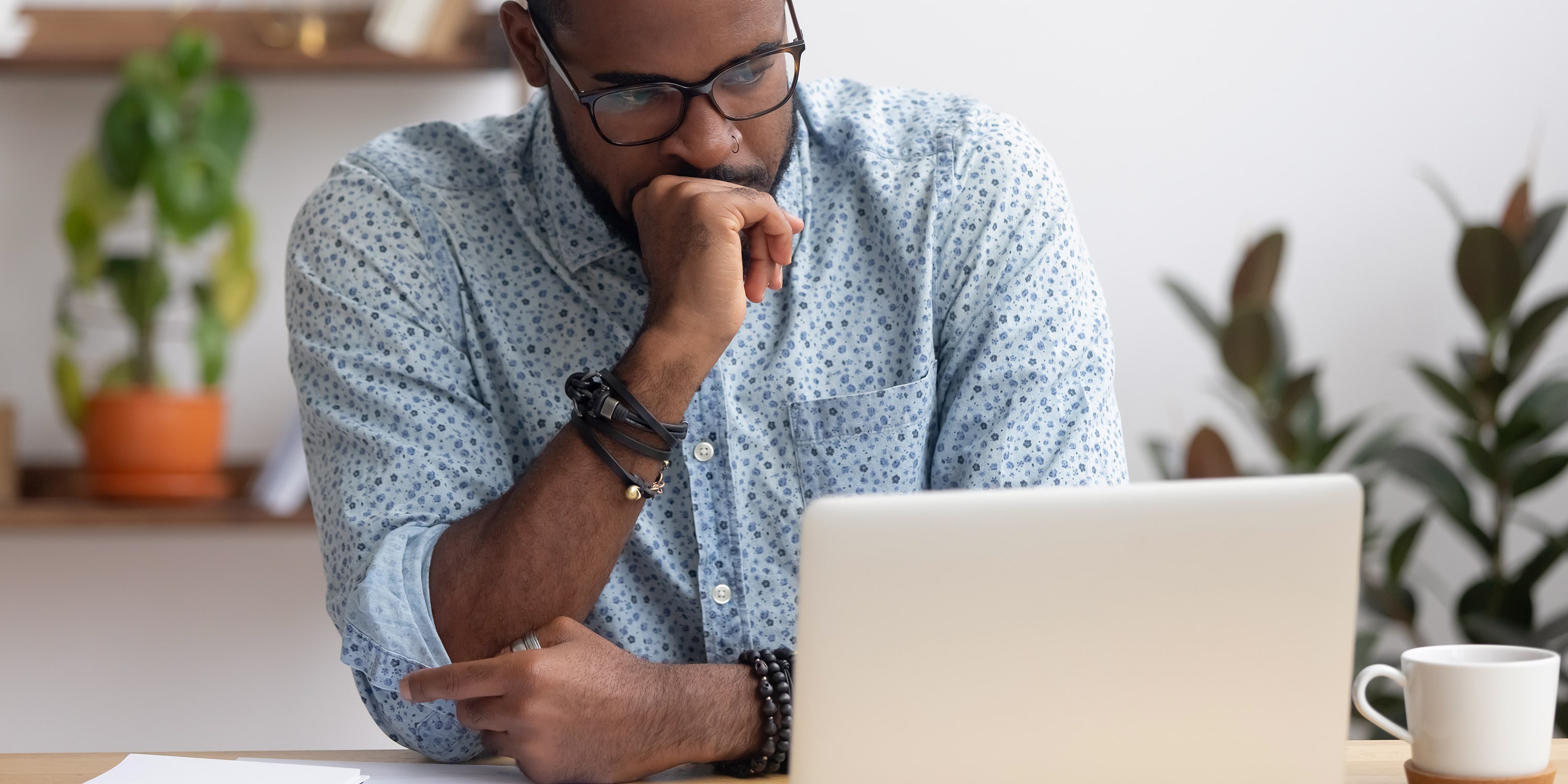 man in front of laptop reading about the different between data management and data governance