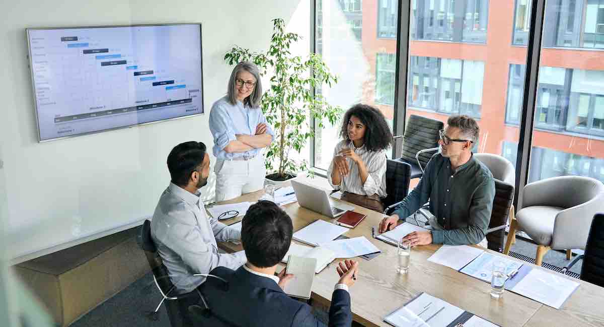 five people discussing digital leadership skills in a meeting room