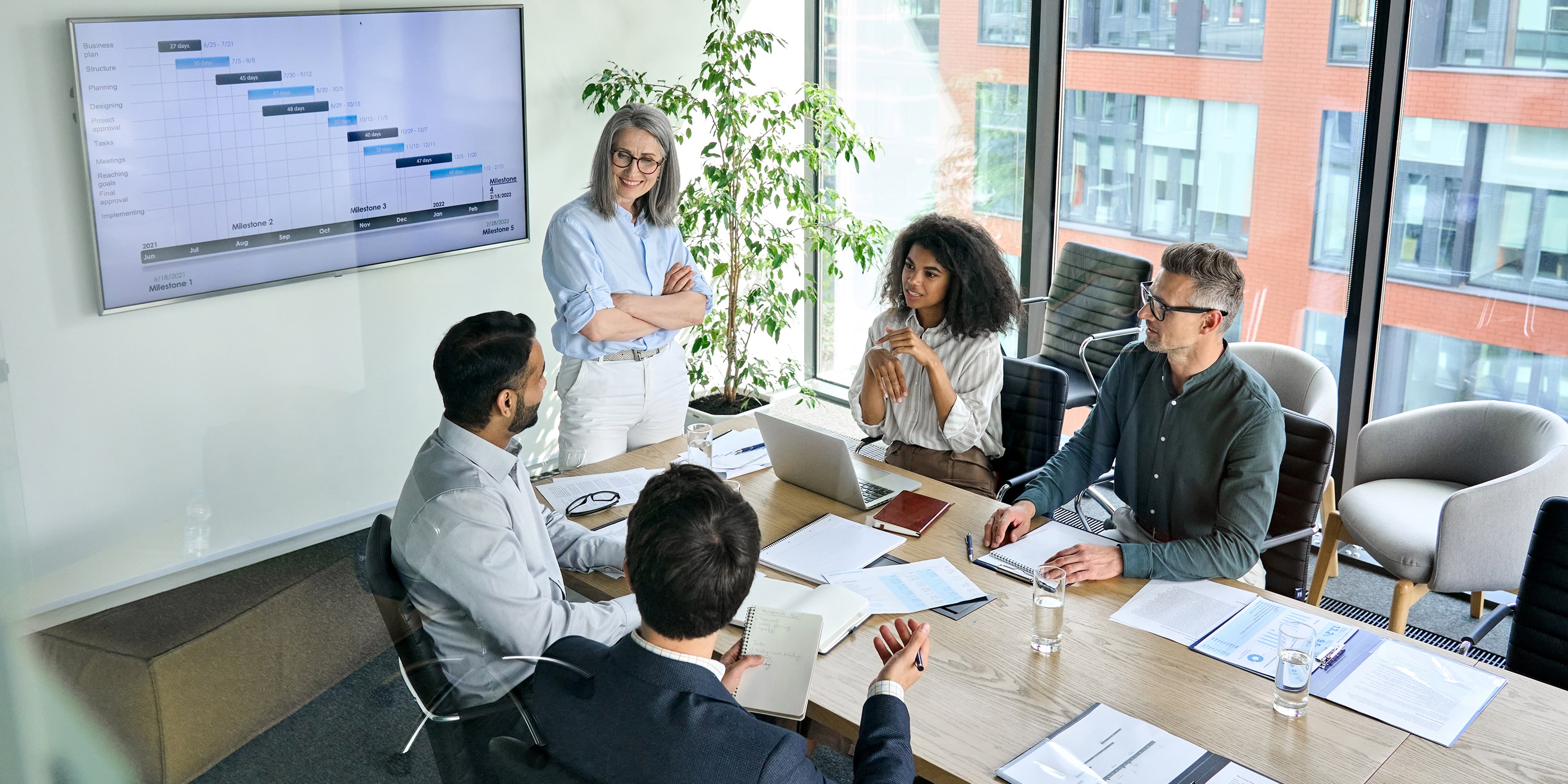 a team of 5 people in a meeting room discussing enterprise architecture business outcomes