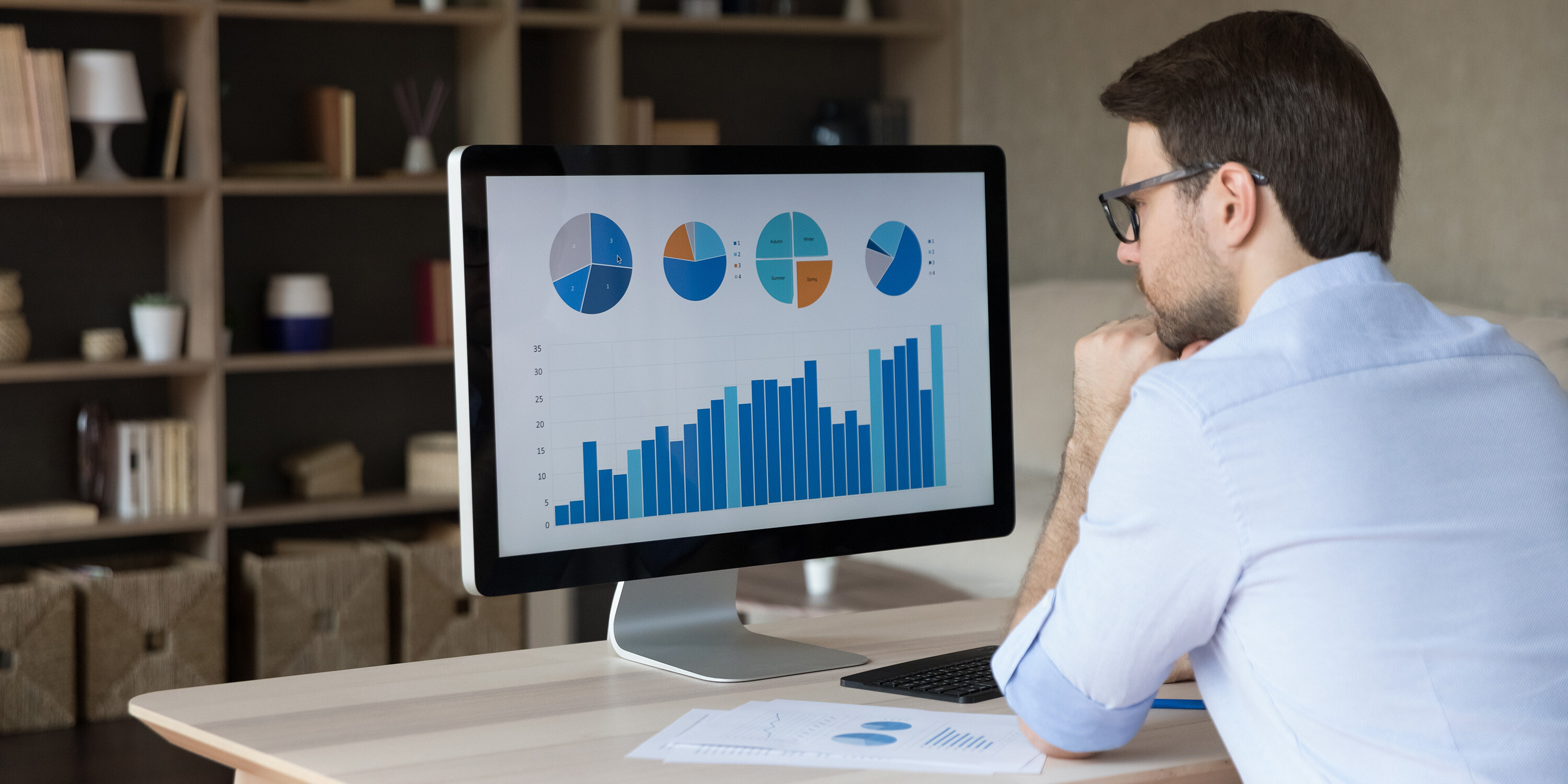 man observing computer screen with charts on it cost reduction